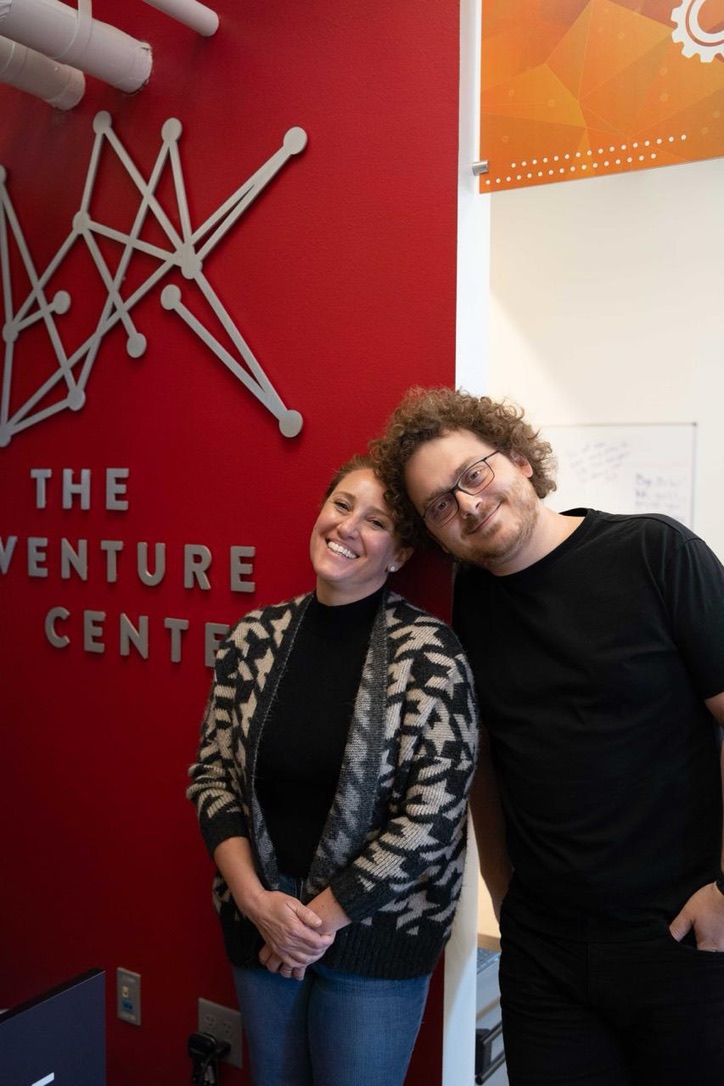 Katy Simmons standing beside a FinTech founder at The Venture Center, both looking at a laptop during a mentoring session